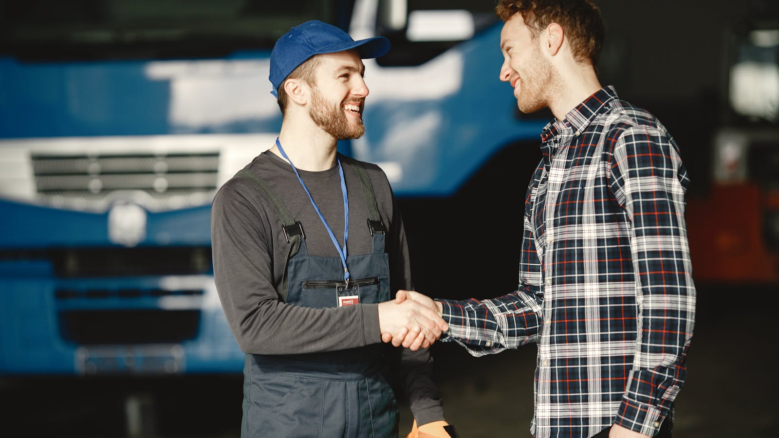 A handshake between a service contractor and a customer in front of a residential home, representing the moment of getting a first paid customer.