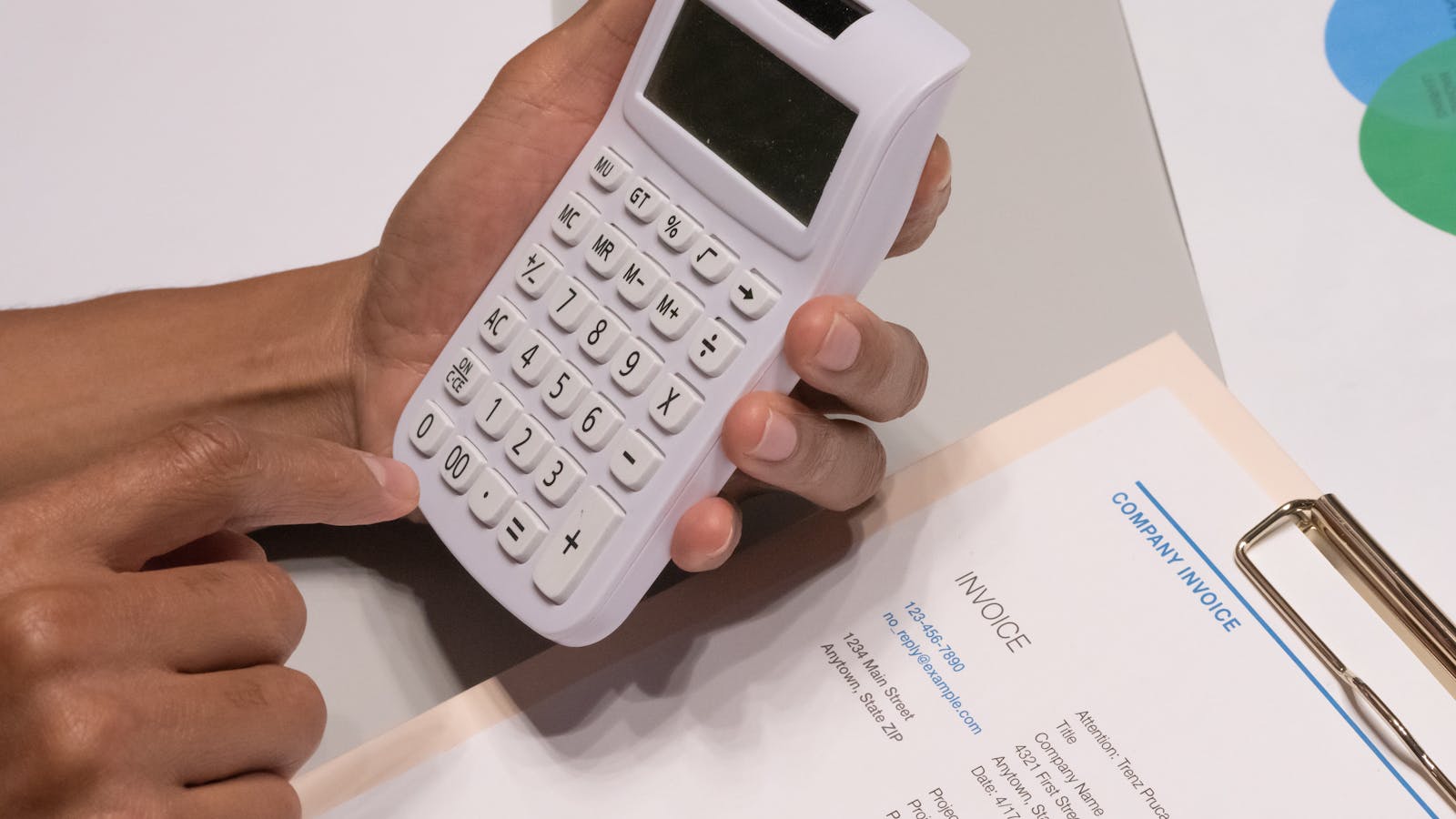A contractor reviewing a job estimate with a calculator, pen, and pricing spreadsheet on a clipboard, representing the honest pricing math behind a service business.